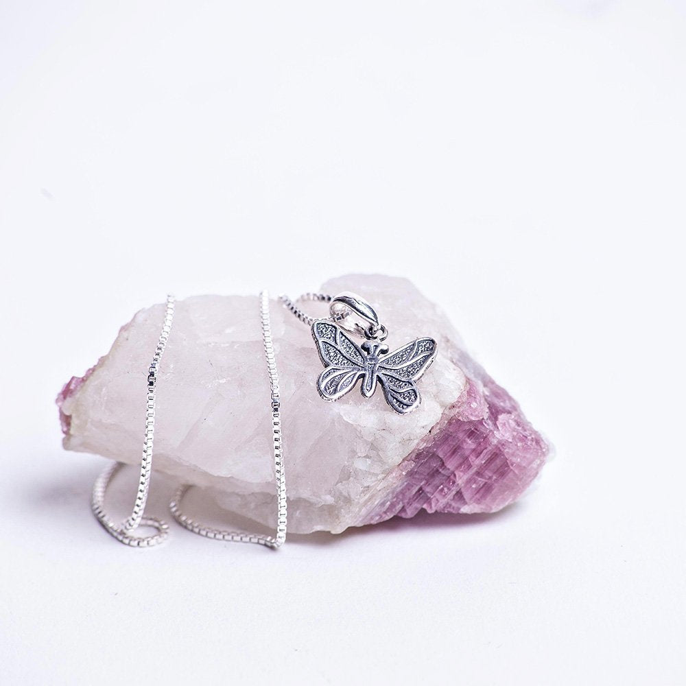 Sterling silver emerging butterfly charm necklace.