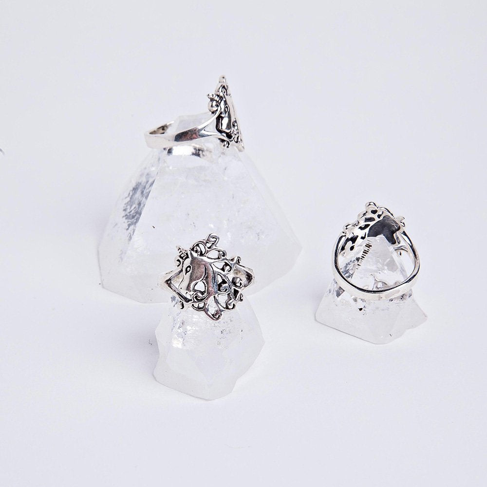 Three sterling silver enchanting unicorn rings sitting on top of apophyllite crystals.