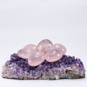 polished + palm stones. rose quartz polished stones sitting on amethyst cluster.