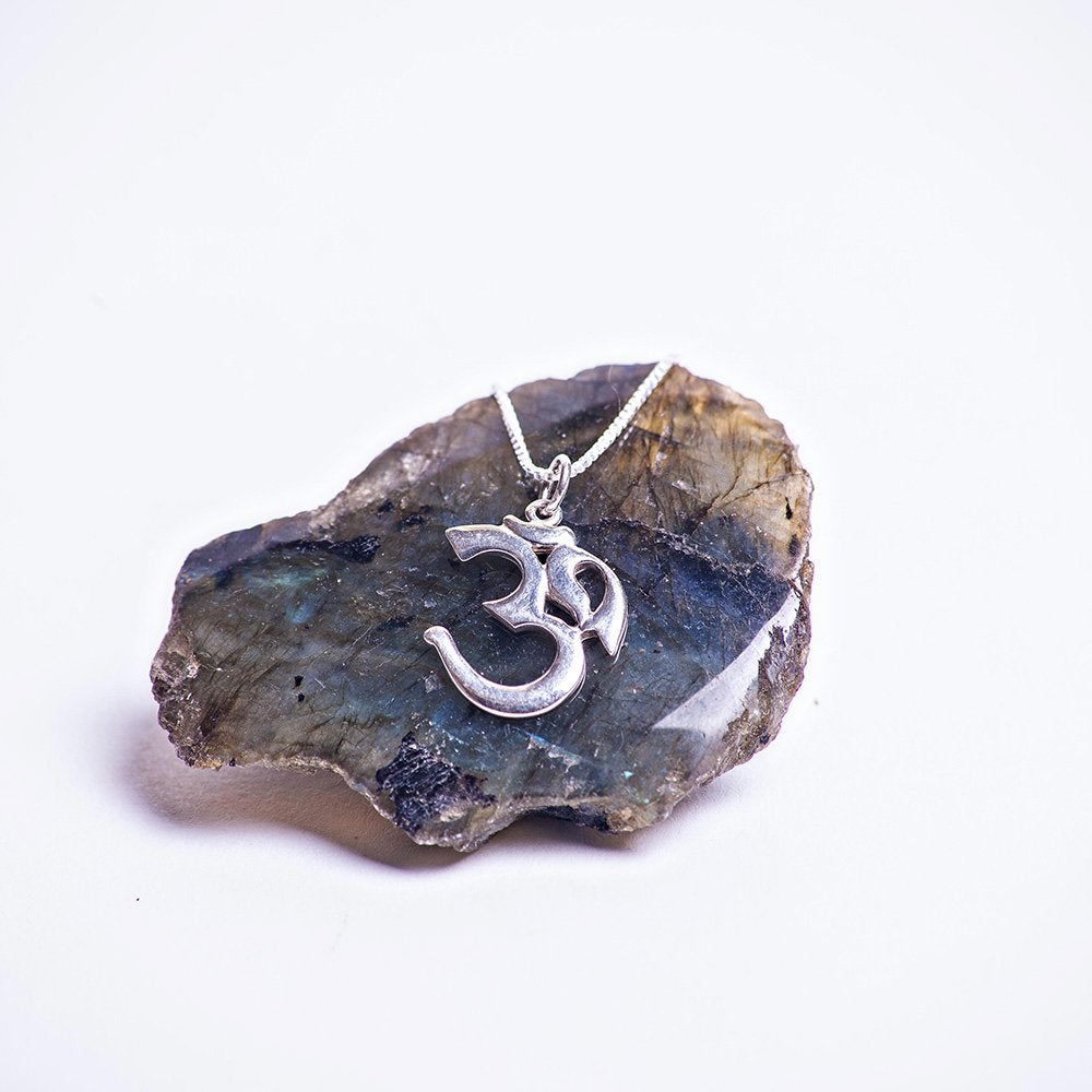Sterling silver om creation charm necklace. Sitting on labradorite.