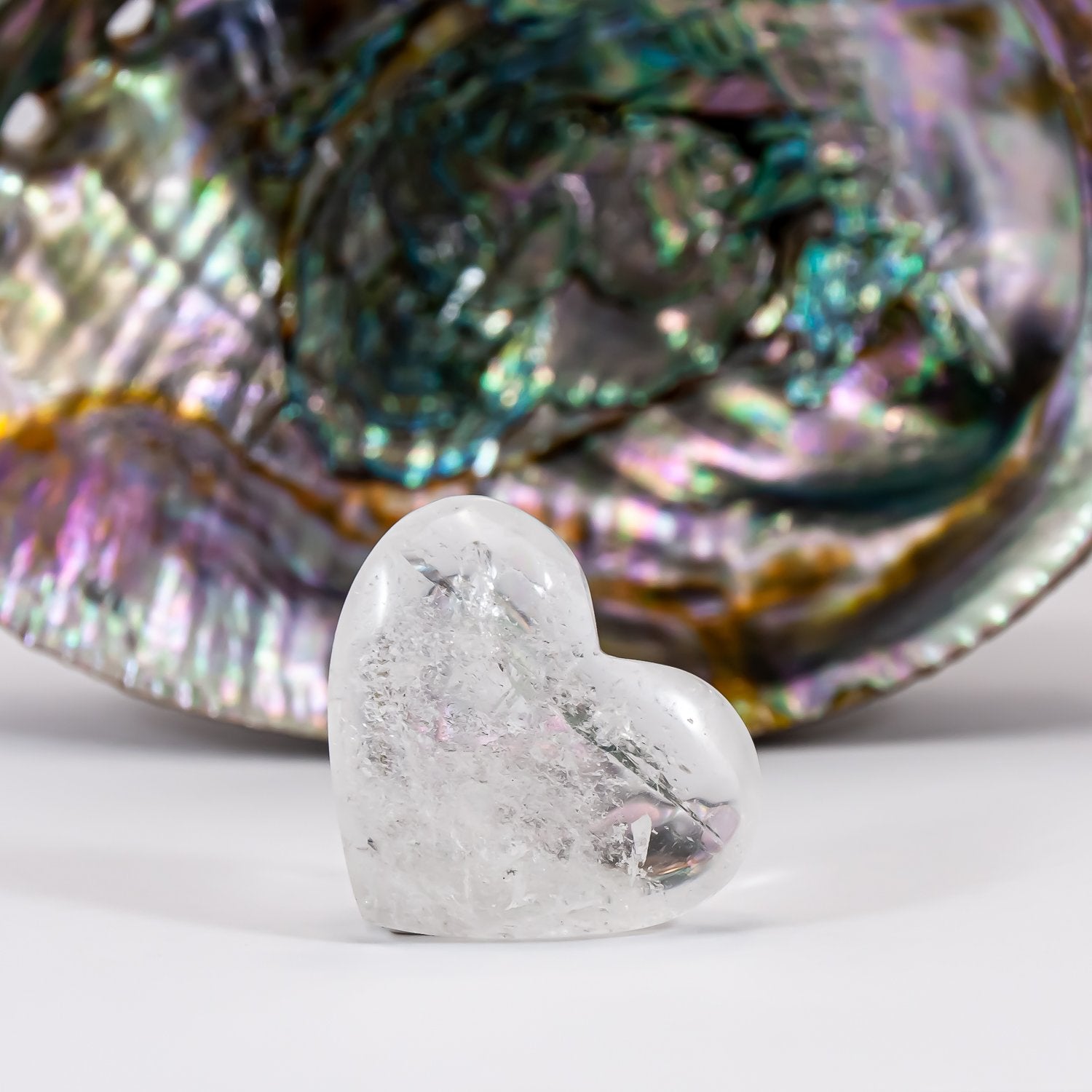 Clear quartz attunement heart close-up. abalone shell in background.