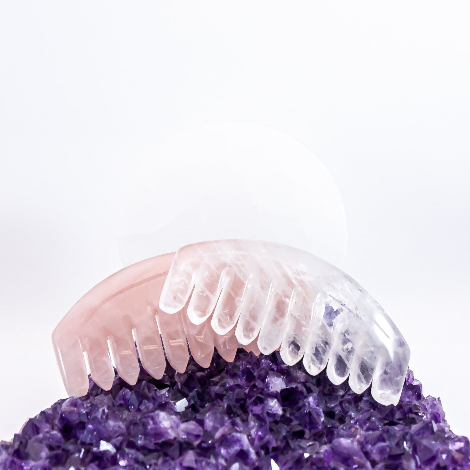 Crystal combs. Rose quartz and clear quartz sitting on amethyst cluster.