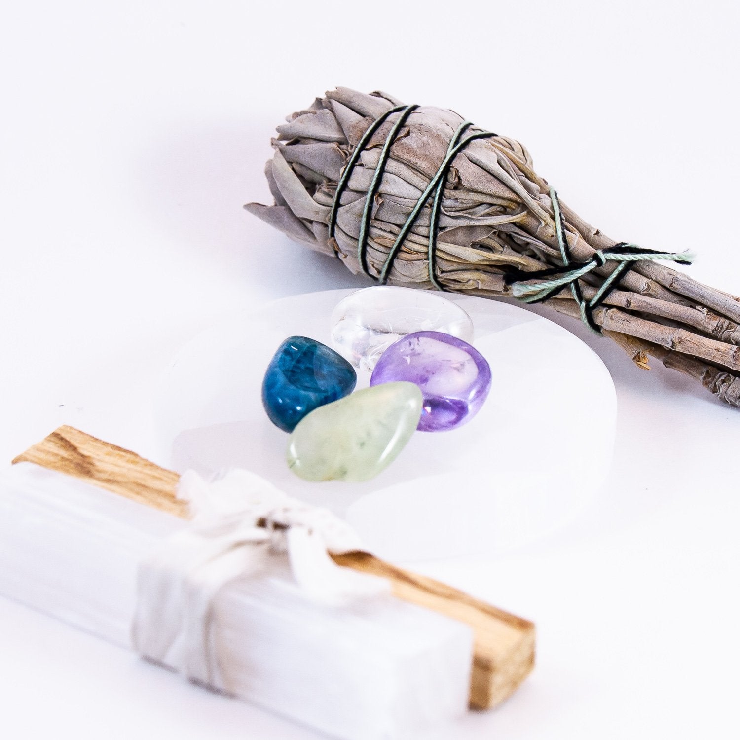 enlightened action crystal set. amethyst, blue apatite, prehnite, and clear quartz. kit includes, 1 white sage smudge, 1 palo santo stick, and 1 selenite mini wand.