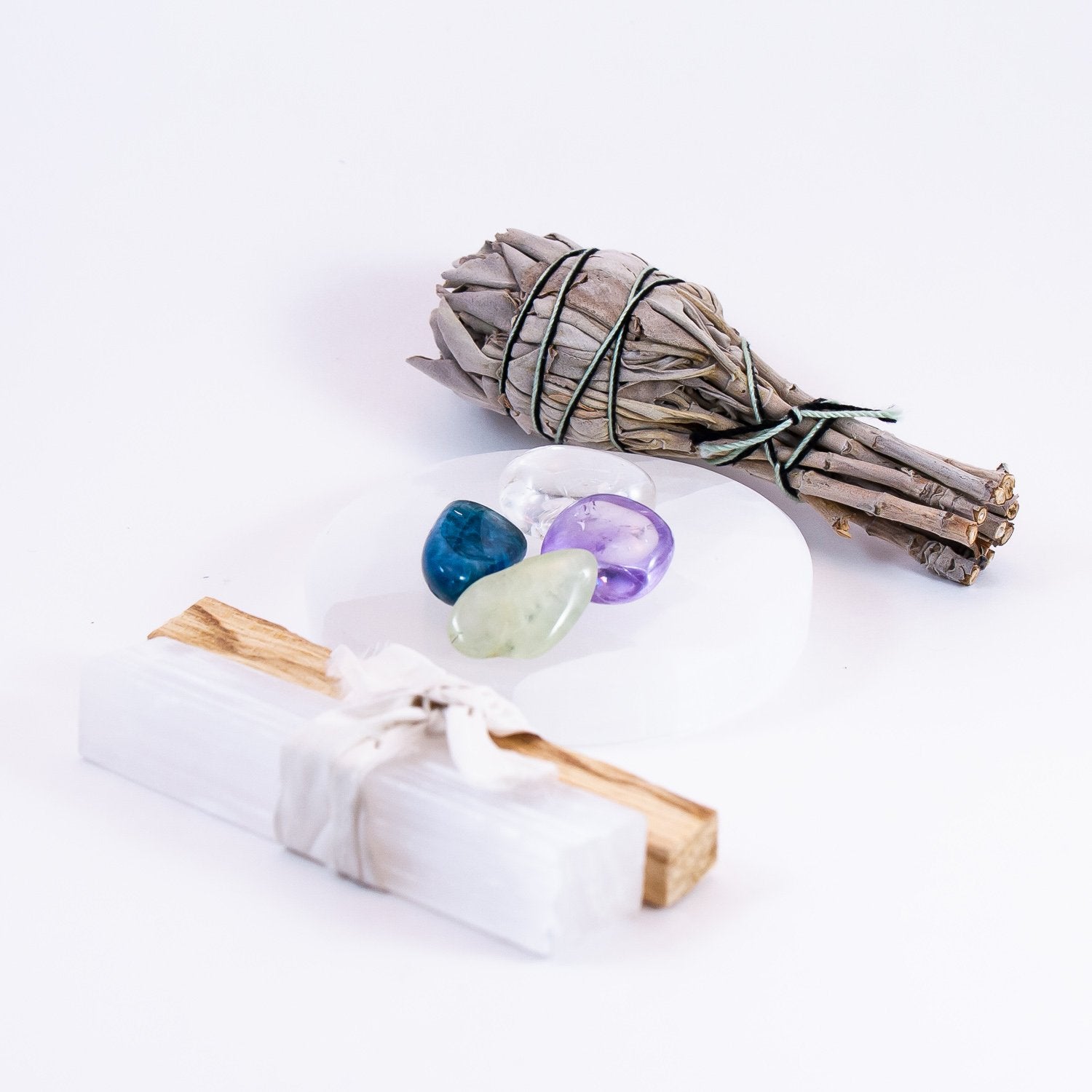 enlightened action crystal set. amethyst, blue apatite, prehnite, and clear quartz. kit includes 1 white sage smudge, 1  palo santo stick, and 1 selenite mini wand.