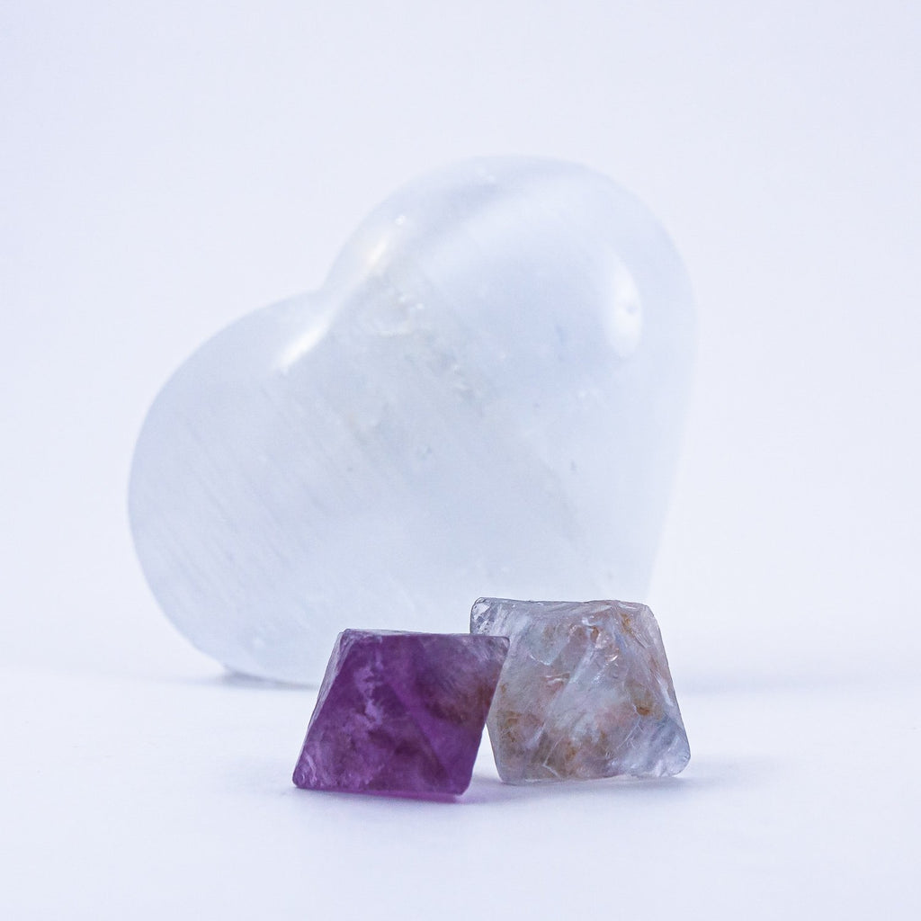 Two fluorite octahedrons as in the giving + receiving stones set. Set in front of a selenite heart.