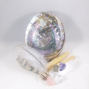 Open image in slideshow, smudge essentials  cleansing kit includes:  abalone, white sage smudge, palo santo, blue slate turkey feather-cruelty free, tumbled stones-rose quartz, amethyst, pyrite, clear quartz.
