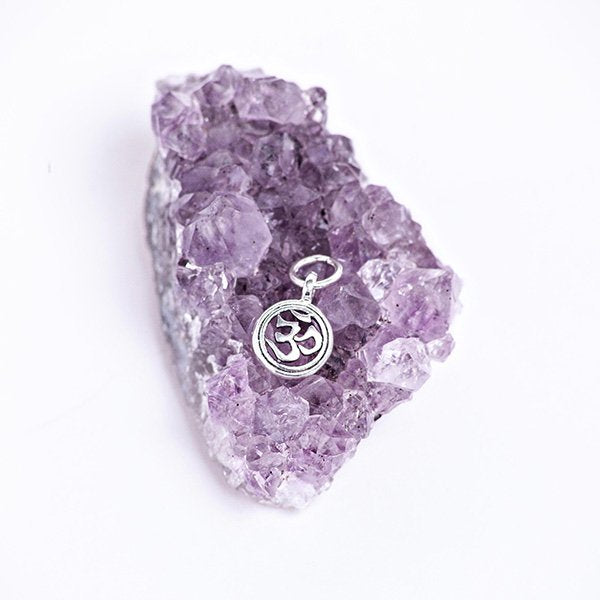 Mini om necklace pendant.Sterling silver. Sitting on an amethyst cluster.