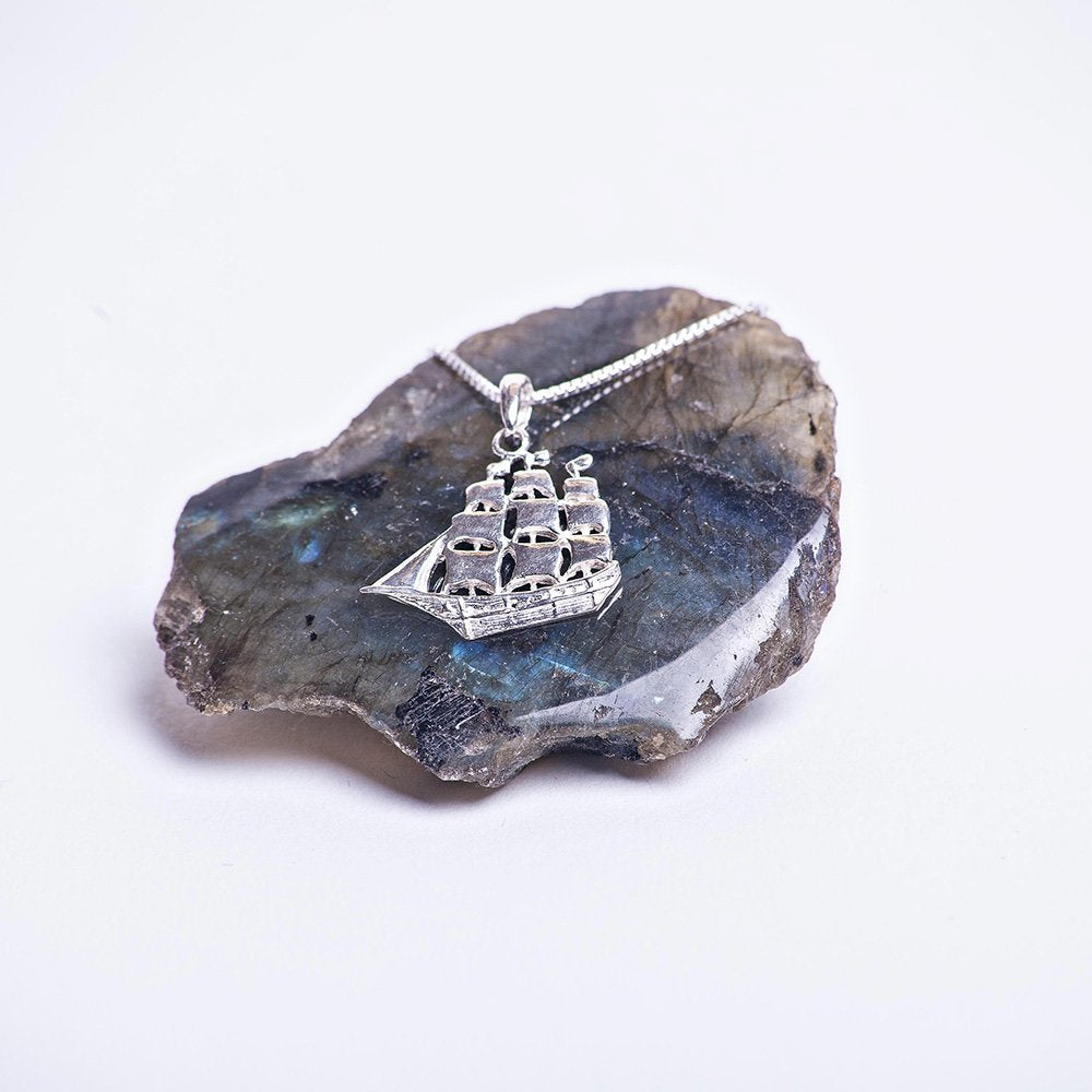 Sterling silver ship charm navigating the sea necklace.